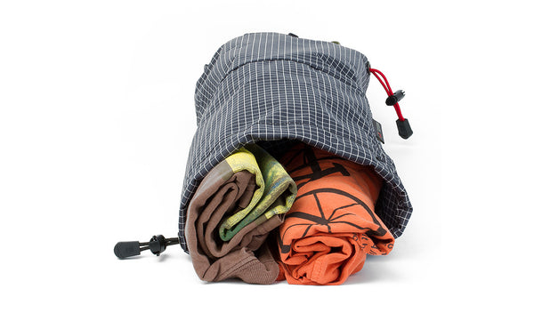 A Travel Laundry Stuff Sack showing a couple of rolled shirts in one side.